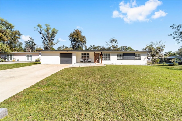 ranch-style house featuring a garage, a front yard, and concrete driveway