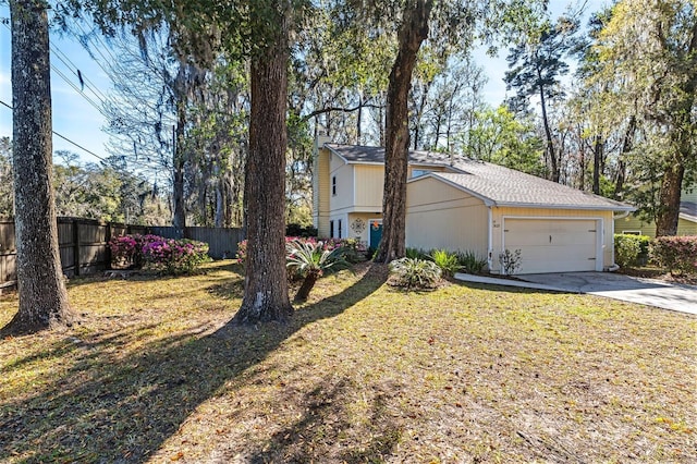 view of front of house featuring a garage, concrete driveway, a front yard, and fence