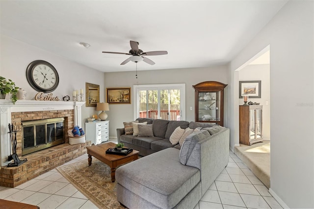 living area featuring light tile patterned floors, a fireplace, and a ceiling fan