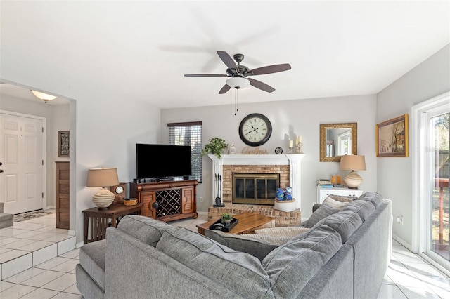 living area featuring light tile patterned flooring, plenty of natural light, a fireplace, and ceiling fan