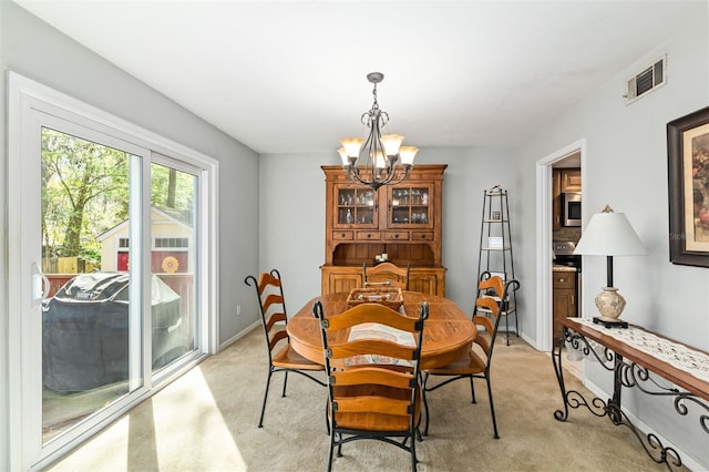 dining area featuring light carpet, baseboards, visible vents, and a notable chandelier