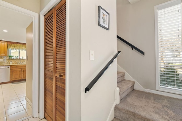 staircase featuring carpet floors, baseboards, and tile patterned floors