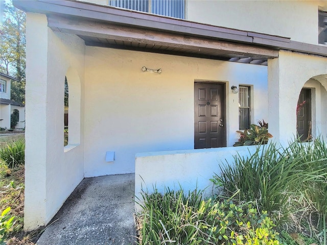 doorway to property featuring stucco siding