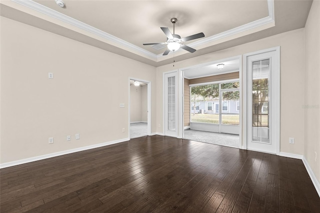 empty room with ceiling fan, baseboards, ornamental molding, wood-type flooring, and a raised ceiling