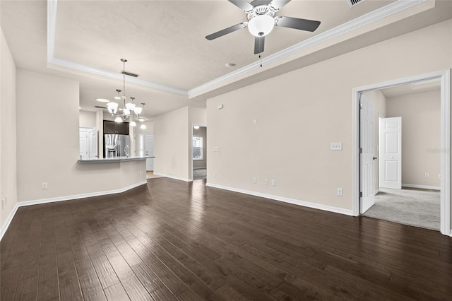 unfurnished living room with a tray ceiling, dark wood-style flooring, visible vents, and baseboards