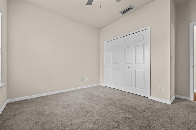 unfurnished bedroom featuring ceiling fan, visible vents, baseboards, a closet, and carpet