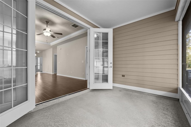 unfurnished room featuring a tray ceiling, crown molding, a ceiling fan, wood walls, and baseboards