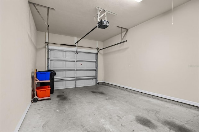 garage featuring a garage door opener and baseboards