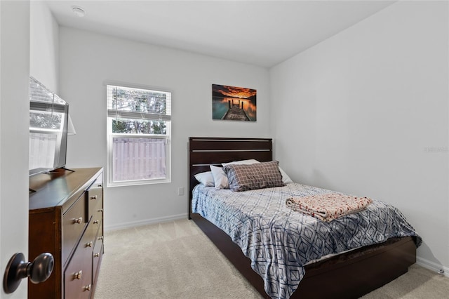 bedroom with baseboards and light colored carpet