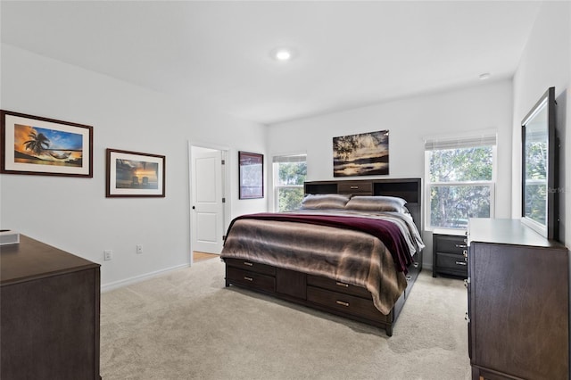 bedroom with light colored carpet, multiple windows, and baseboards