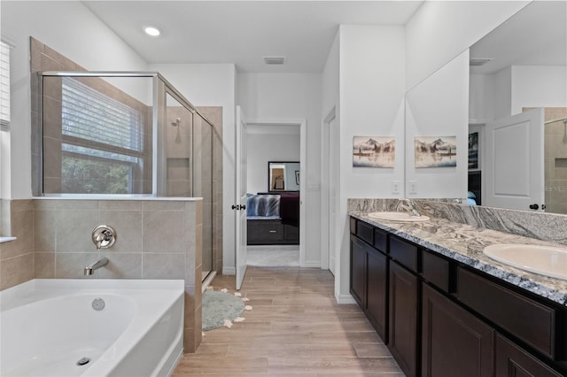 ensuite bathroom with a garden tub, a sink, a shower stall, and ensuite bath