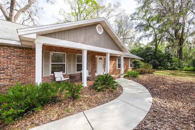 view of front of home featuring a porch and brick siding