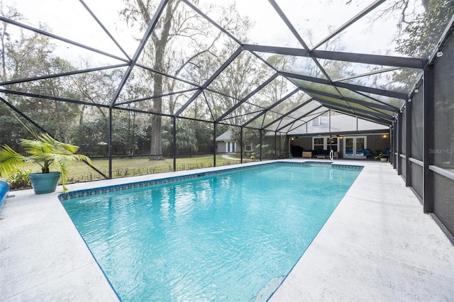 pool with glass enclosure, a yard, a patio, and french doors