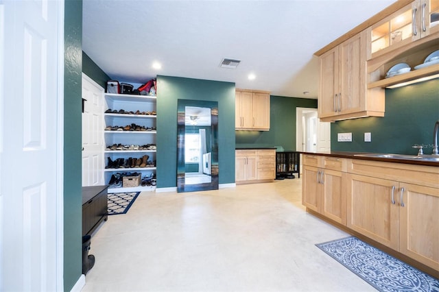 kitchen featuring open shelves, visible vents, light brown cabinets, and a sink