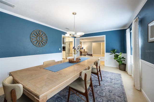 dining room featuring visible vents, ornamental molding, and an inviting chandelier