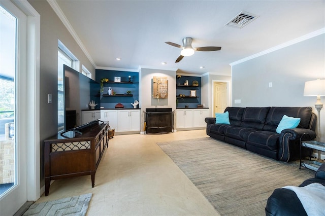 living area featuring built in shelves, ceiling fan, ornamental molding, visible vents, and recessed lighting