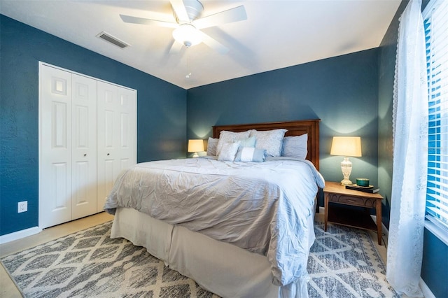 bedroom with baseboards, a ceiling fan, visible vents, and a closet