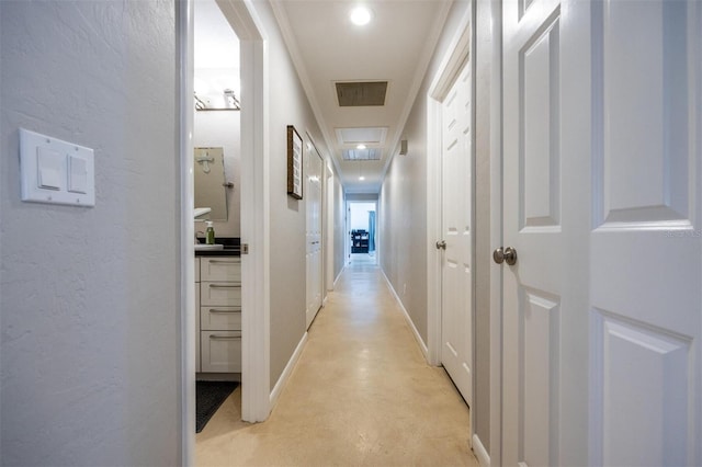 hall with baseboards, visible vents, and concrete floors