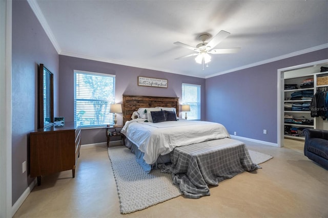 bedroom with a spacious closet, a ceiling fan, a closet, crown molding, and baseboards