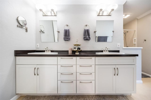 full bath with baseboards, ornamental molding, a sink, and double vanity