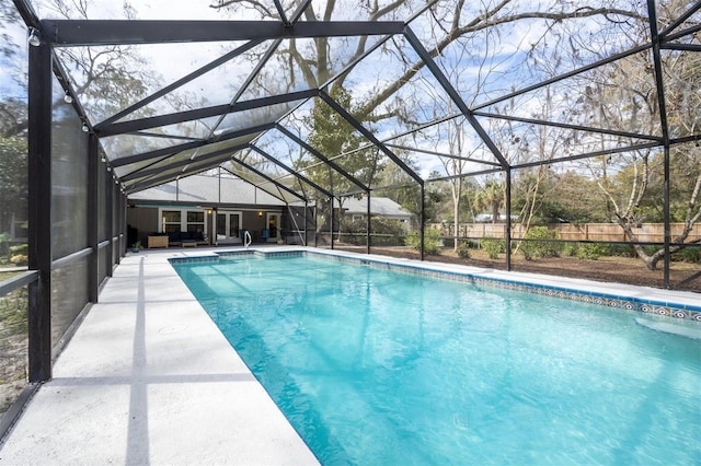 view of pool with a patio area, a fenced in pool, and glass enclosure