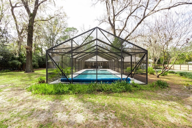 pool with a yard and glass enclosure