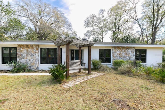 view of front of house with stone siding, a front lawn, and a pergola