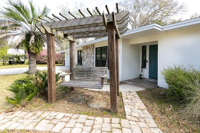 exterior space with covered porch, stucco siding, and a pergola