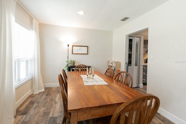 dining area featuring wood finished floors, visible vents, and baseboards