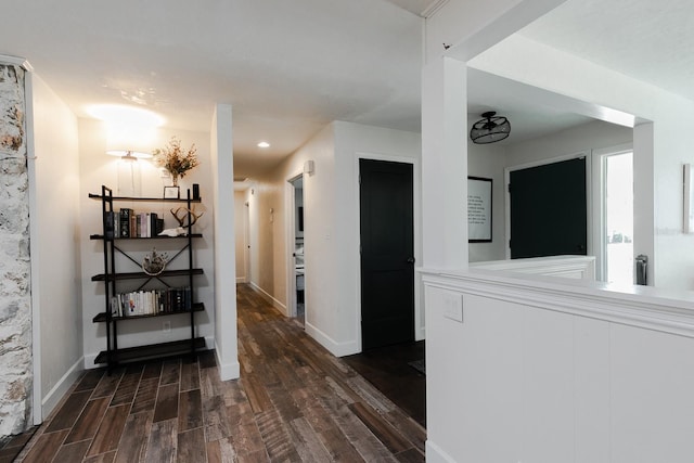 hallway with dark wood-type flooring and baseboards