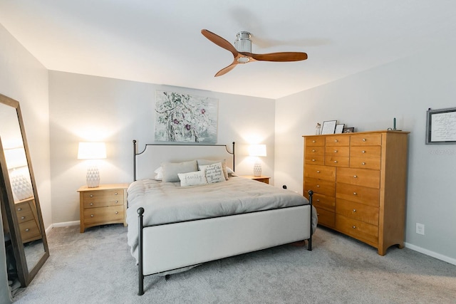 bedroom featuring light colored carpet, baseboards, and ceiling fan