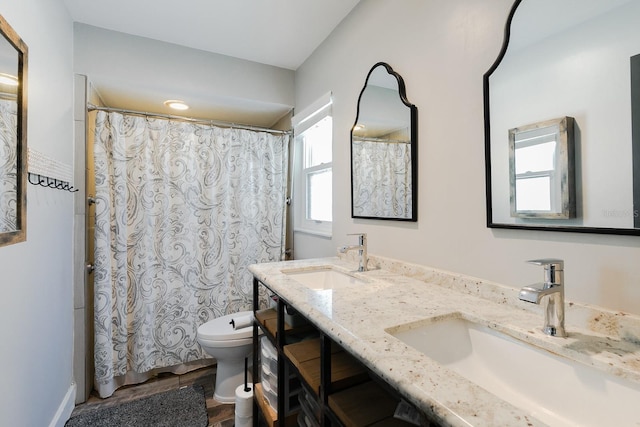 full bath with a shower with shower curtain, double vanity, toilet, and a sink