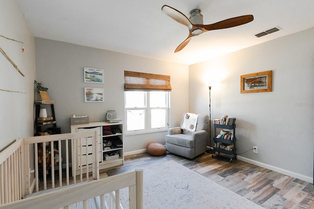 bedroom featuring ceiling fan, wood finished floors, visible vents, and baseboards