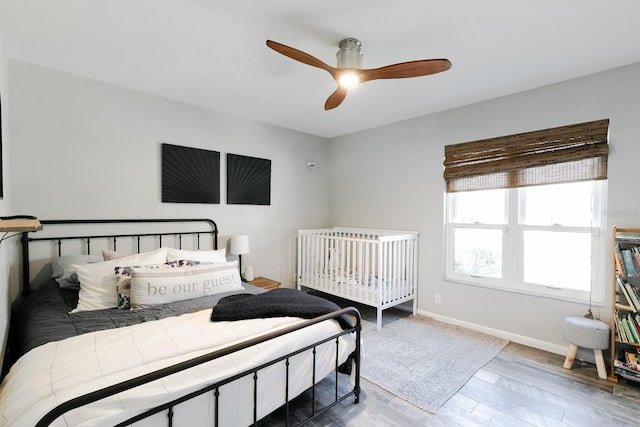 bedroom with ceiling fan, baseboards, and wood finished floors