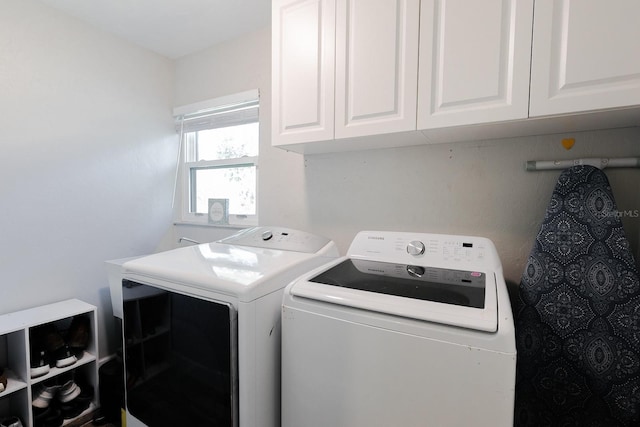 washroom with washing machine and dryer and cabinet space