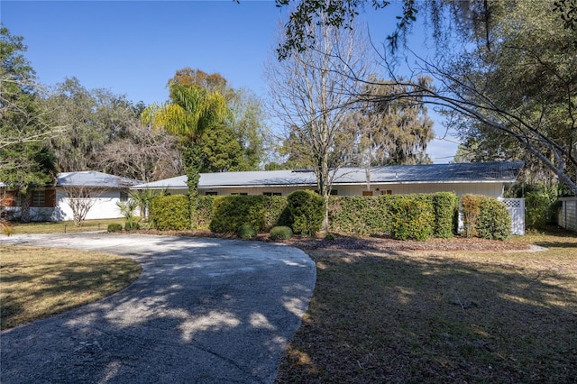 ranch-style home featuring driveway and a front yard