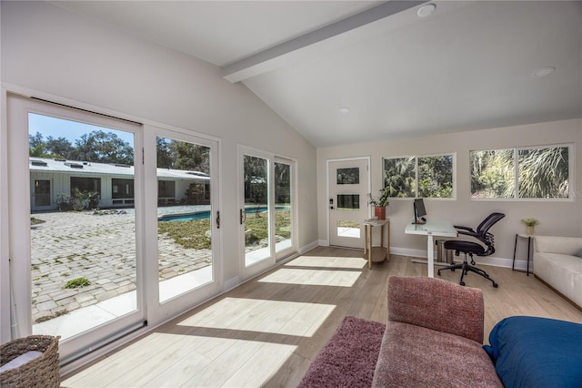 sunroom / solarium featuring vaulted ceiling with beams