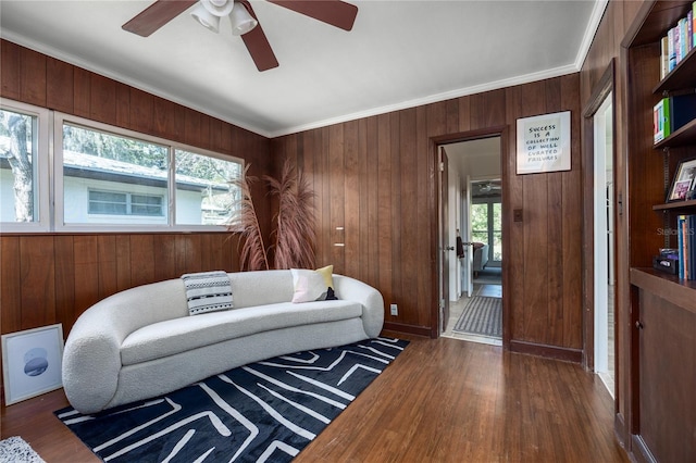 sitting room with dark wood-style floors, a wealth of natural light, and ornamental molding