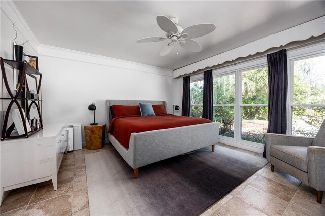 bedroom with stone finish flooring, multiple windows, ornamental molding, and a ceiling fan