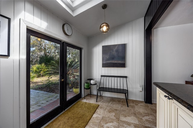 doorway to outside featuring a skylight and stone finish flooring