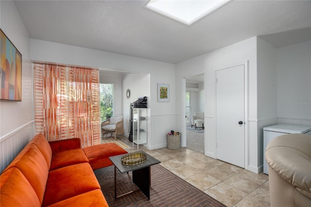 living area featuring wainscoting and a skylight