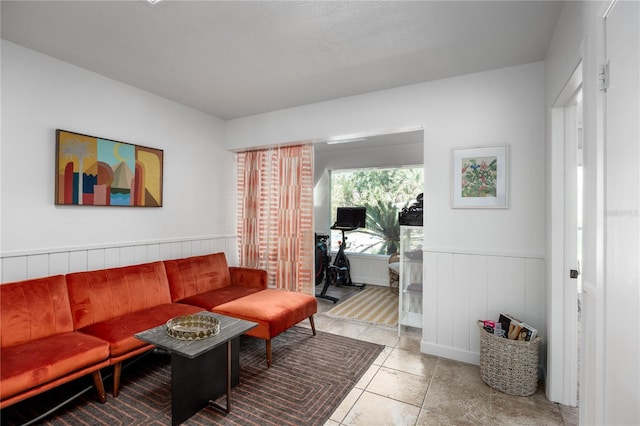 living area featuring wainscoting and tile patterned floors