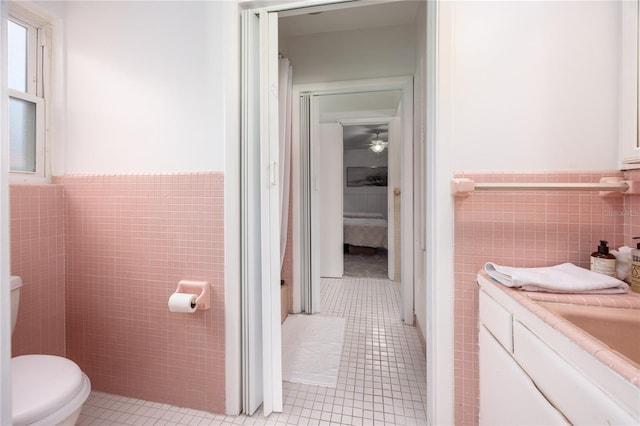 bathroom with a wainscoted wall, tile walls, and tile patterned floors