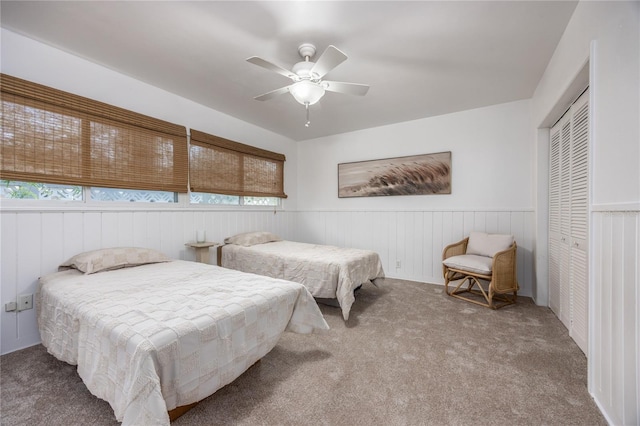 bedroom with multiple windows, wainscoting, and a closet