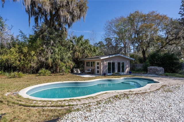 pool with an outbuilding, a storage structure, a patio area, and fence