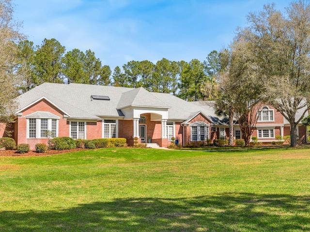 view of front of house with a front yard and brick siding