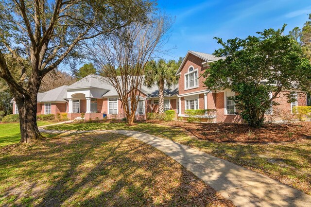 view of front of house featuring brick siding and a front lawn