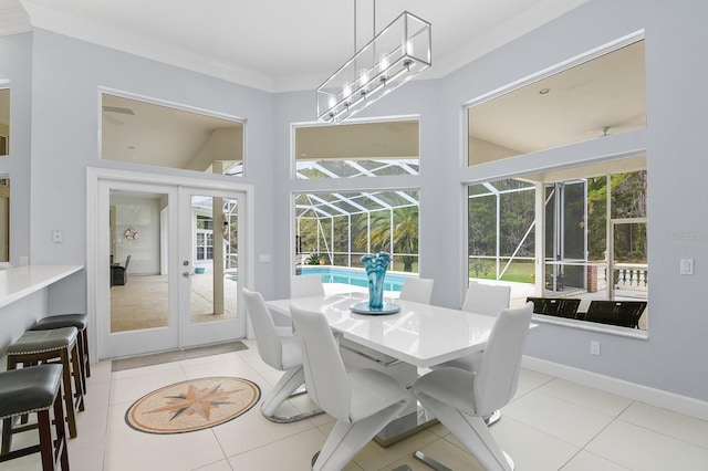 dining room with light tile patterned floors, a sunroom, baseboards, french doors, and crown molding