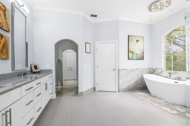 full bathroom with visible vents, crown molding, vanity, and a freestanding bath