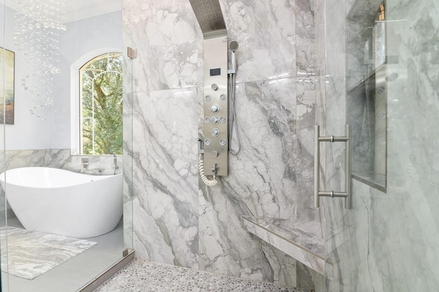 bathroom with a marble finish shower and a freestanding bath